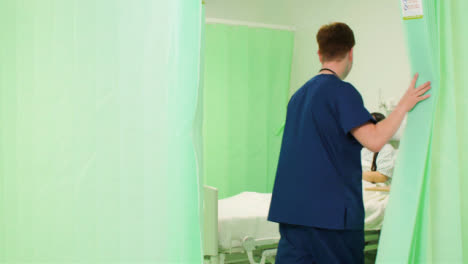 Enfermero-de-sexo-masculino-que-abre-la-cortina-del-hospital