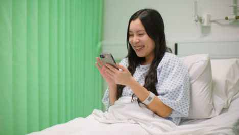 Lächelnde-Weibliche-Krankenhauspatientin-Mit-Telefon