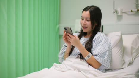 Happy-Female-Hospital-Patient-Using-Teléfono