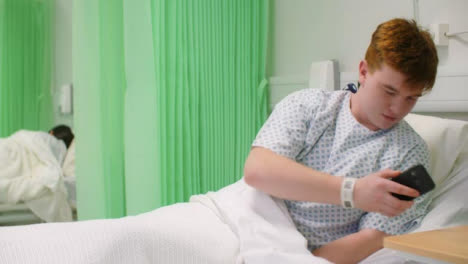 Paciente-masculino-del-hospital-en-la-cama-recoge-el-teléfono