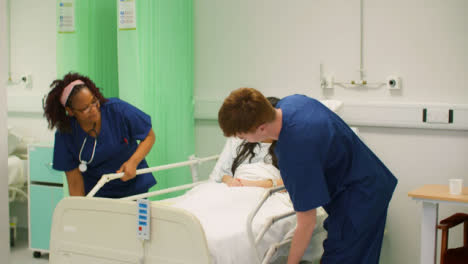 Two-Nurses-Put-Down-Hospital-Bed-Rails-
