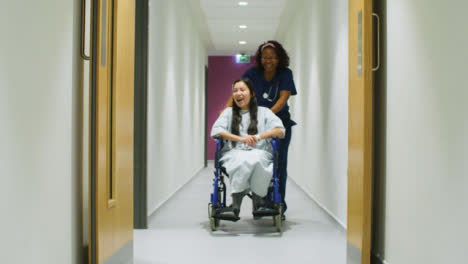 Enfermera-empuja-paciente-feliz-en-silla-de-ruedas