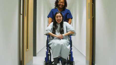 Krankenschwester,-Die-Glückliche-Patientin-Im-Rollstuhl-Schiebt