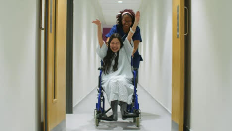 Female-Nurse-Having-Fun-With-Patient-In-Wheelchair