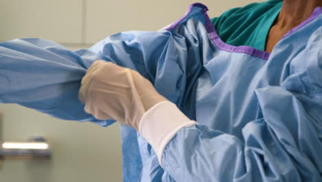 CU-Surgeon-Puts-On-Surgical-Gown