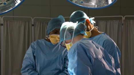 Cirujanos-de-pie-mirando-hacia-abajo-en-la-cirugía