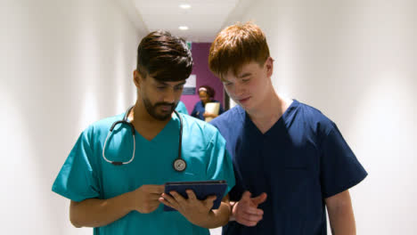 Zwei-Medizinisches-Personal-Mit-Tablet-Im-Korridor