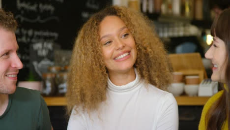 Group-Of-Friends-Talking-And-Laughing-In-Cafe