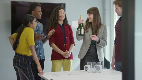 Business-Team-Get-Ready-To-Celebrate-At-Work-With-Champagne