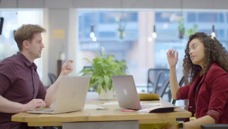 Pan-Of-Man-And-Woman-Talking-And-Working-In-Modern-Office