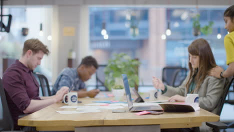 Woman-talking-to-colleague-in-open-plan-office