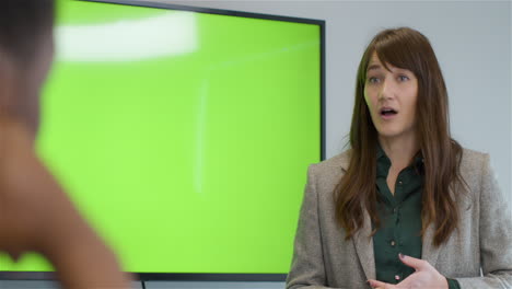 Businesswoman-Talking-To-Colleagues-With-Green-Screen-Tv