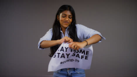 Young-Woman-Rips-Stay-Home-Stay-Safe-Sign