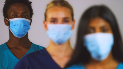 3-Young-Doctors-Wearing-Protective-Face-Masks-Pull-Focus