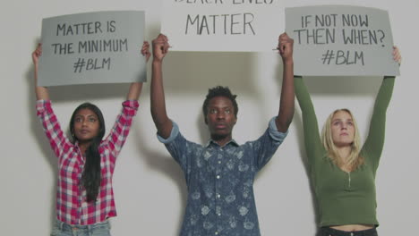 3-Junge-Leute-Halten-Anti-Rassismus-Schilder