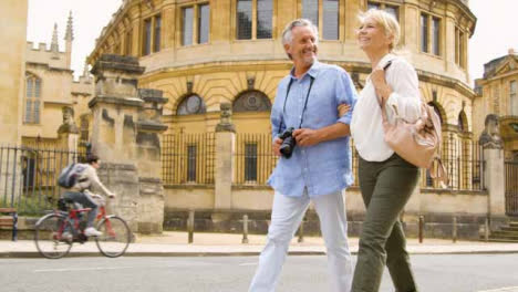 Low-Angle-Shot-of-Middle-Aged-Tourist-Couple-Exploring-City-Streets