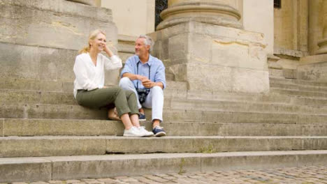 Low-Angle-Shot-of-Laughing-Middle-Aged-Tourist-Couple-On-Old-Steps