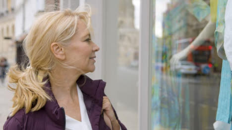 Close-Up-of-Middle-Aged-Woman-Window-Shopping-In-City