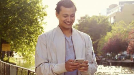 Tracking-Shot-of-Man-Texting-and-Enjoying-Walk-by-Canal