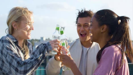 Close-Up-of-3-Friends-Enjoying-a-Drink-On-a-City-Roof-Terrace