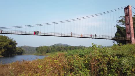 Wide-angle-panning-shot-of-tourists-on-the-famous-hanging-bridge-across-the-Periyar-río-in-Idukki-district-Kerala-India