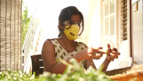 Nahaufnahme-Einer-Südindischen-Frau-Mit-Maske-Und-Schutzbrille,-Die-Während-Der-Covid19-Coronavirus-Pandemie-Blätter-Aus-Spinat-Pflückt