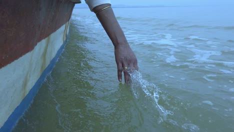 Nahaufnahme-Einer-Mädchenhand,-Die-Das-Wasser-Von-Einem-Boot-Auf-Einem-See-Fühlt?