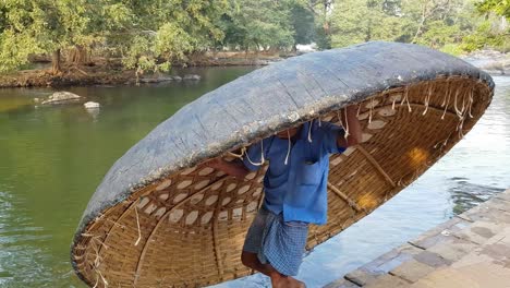 A-man-dropping-a-coracle-in-the-Cauvery-river-in-Hogenakkal-Tamil-Nadu-India