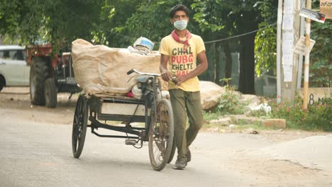 Bengaluru-Karnataka-Indien-15.-Mai-2020-Ein-Armer-Müllsammler,-Der-Maske-Trägt-Und-Müll-Auf-Einem-Dreirad-Während-Der-Covid19-Pandemie-Sammelt-Collecting