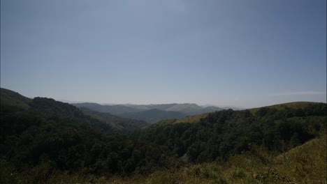 Wide-angle-panning-shot-of-beautiful-mountain-ranges-on-a-sunny-afternoon-with-clear-blue-sky