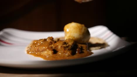 Closeup-dolly-out-dramatic-slow-motion-shot-of-parotta-and-chicken-curry-on-a-plate-with-a-boiled-egg-being-served-slowly-coming-into-focus	