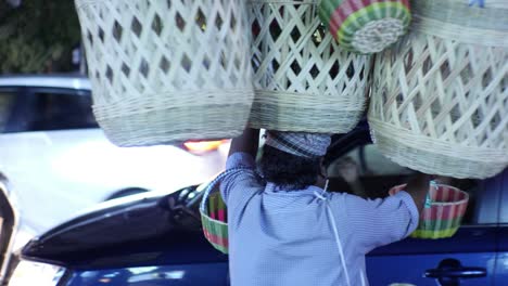 Bengaluru-Karnataka--India--January-25-2020-Medium-shot-of-a-middle-aged-asian-man-selling-basket-made-out-of-cane-on-busy-road-during-night-time