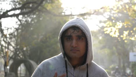 Closeup-of-adult-asian-man-wearing-hoodie-sweat-shirt-and-jogging-during-dawn