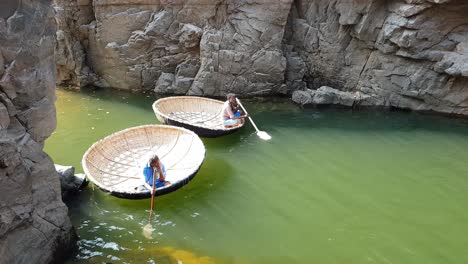 Hogenakkal-Tamilnadu-Indien-22.-Dez.-2018-Zwei-Männer-Warten-Auf-Einen-Coracle,-Der-Auf-Dem-Wasser-Im-Fluss-Cauvery-Schwimmt.