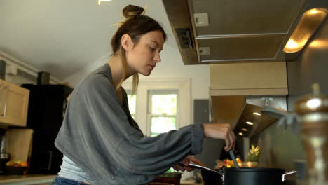 Mujer-Joven-Cocinando-Y-Revolviendo-El-Contenido-De-La-Olla