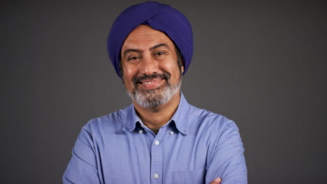 Pull-Focus-of-Middle-Aged-Man-In-Turban-Folding-Arms-and-Smiling