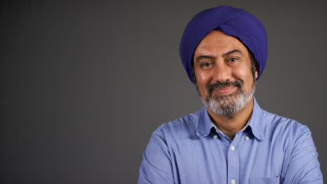 Middle-Aged-Man-In-Turban-Folds-His-Arms-and-Smiles-Portrait