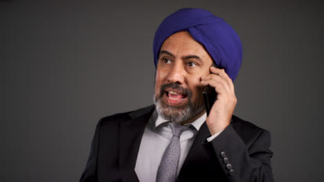 Angry-Middle-Aged-Businessman-In-Turban-Shouting-On-Phone
