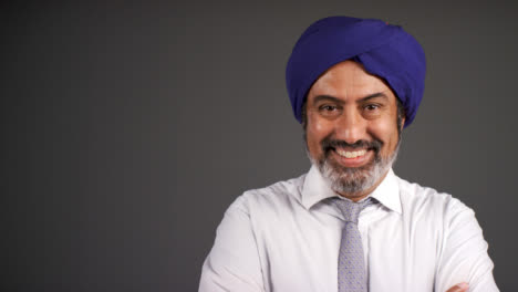 Smart-Middle-Aged-Man-In-Turban-Folding-Arms-and-Smiling