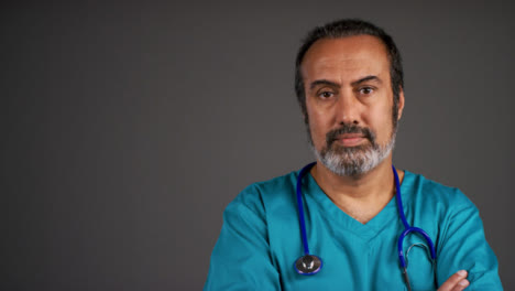 Middle-Aged-Doctor-Folding-Arms-and-Looking-Serious-Portrait