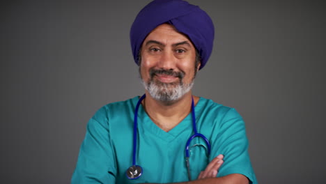 Pull-Focus-of-Middle-Aged-Doctor-In-Turban-Folding-Arms-and-Smiling