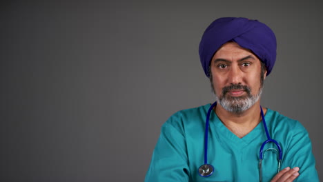 Middle-Aged-Doctor-In-Turban-Folding-Arms-and-Looking-Serious