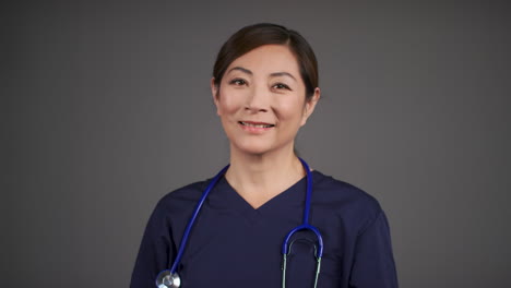 Middle-Aged-Doctor-Removing-Her-Face-Mask-and-Smiling