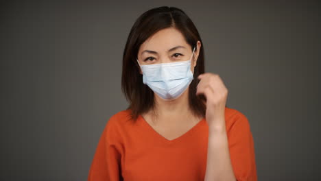 Middle-Aged-Woman-Removing-Face-Mask-and-Smiling