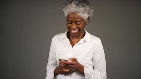 Mujer-Elegantemente-Vestida-Sonriendo-Para-Sí-Misma-Mientras-Envía-Mensajes-De-Texto