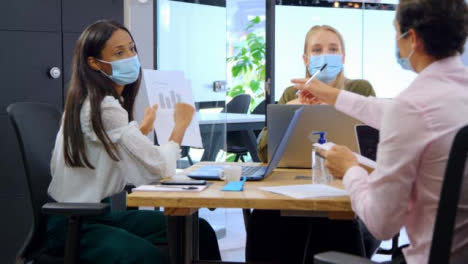 Three-Young-Business-Colleagues-In-Face-Masks-Having-a-Meeting
