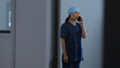 Concerned-Middle-Aged-Surgeon-Talking-On-Her-Mobile-Teléfono