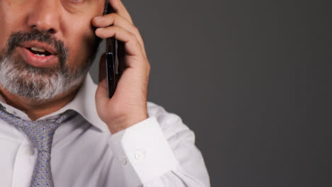 Middle-Aged-Businessman-Having-Heated-Phone-Call-Portrait