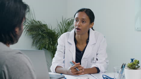 Young-Doctor-Uses-Clipboard-Whilst-Talking-to-Patient