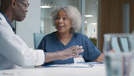 Two-Medical-Professionals-Having-Work-Meeting-In-Office-Space